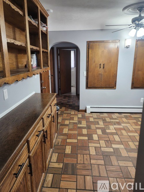 A kitchen with wooden cabinets and a tiled floor.