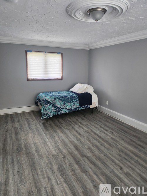 A bedroom with a bed and a window.