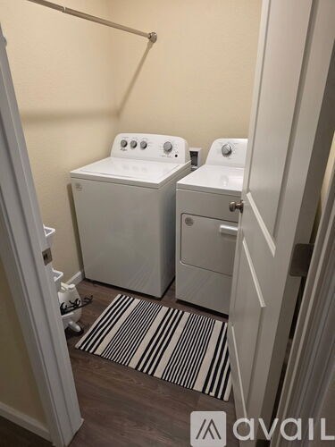 A bathroom with two toilets and a striped rug.