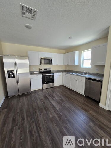 A kitchen with wood floors and stainless steel appliances.