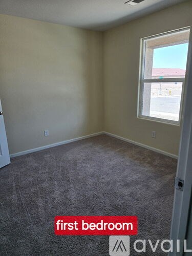 A room with a carpeted floor and a window.