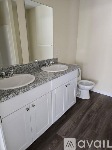 A bathroom with a granite countertop and white cabinets.