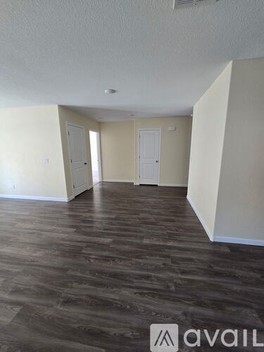 A room with wooden flooring and two white doors.