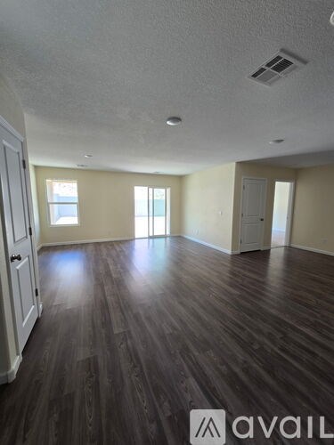 A room with wooden floors and two windows.