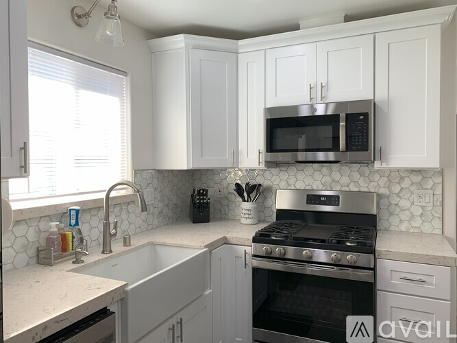 A kitchen with white cabinets and a stainless steel stove.