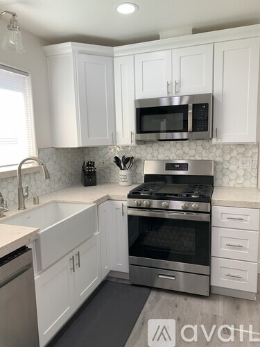 A kitchen with white cabinets and a stainless steel oven.