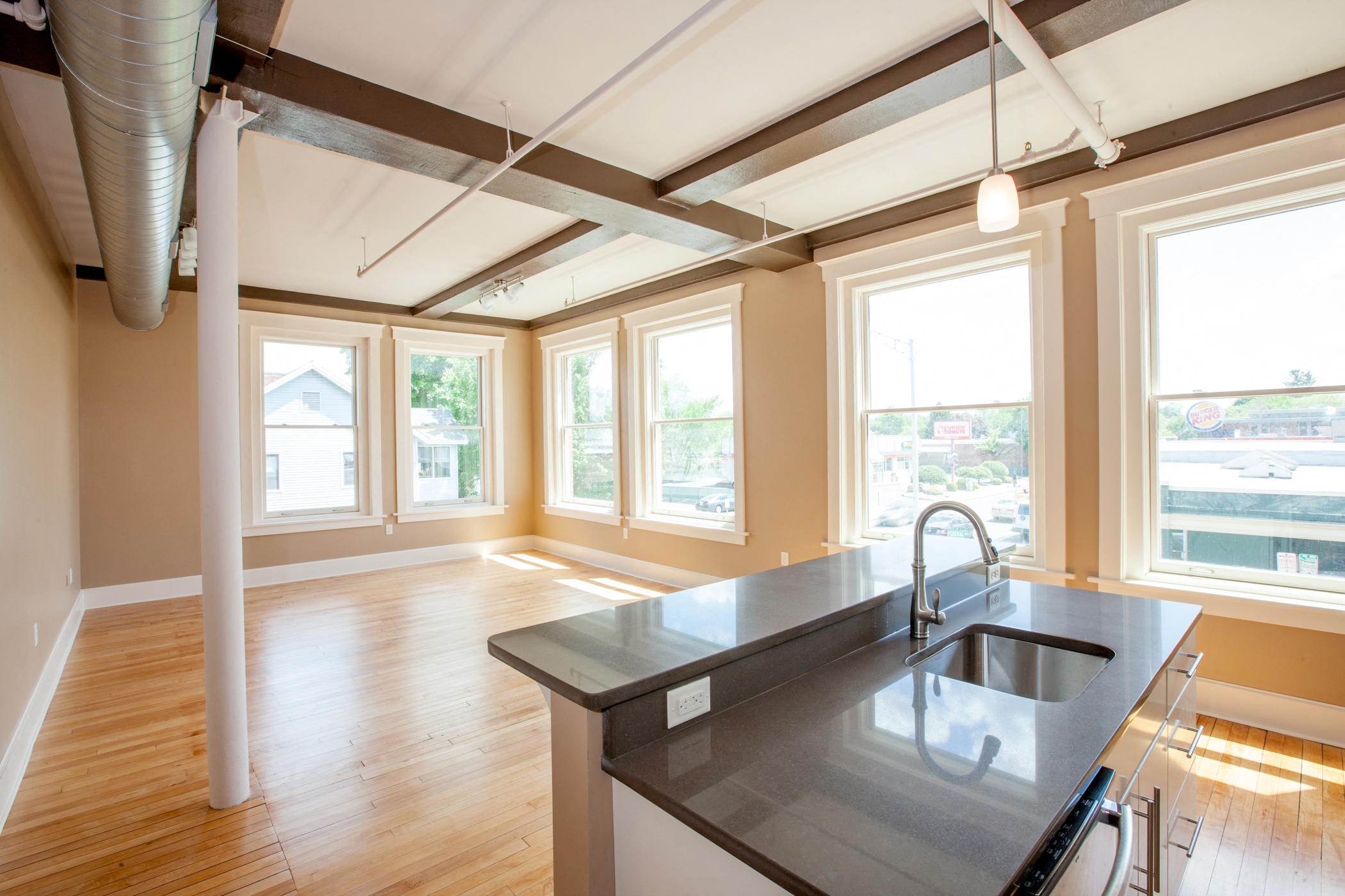 an empty kitchen with a large window and a sink