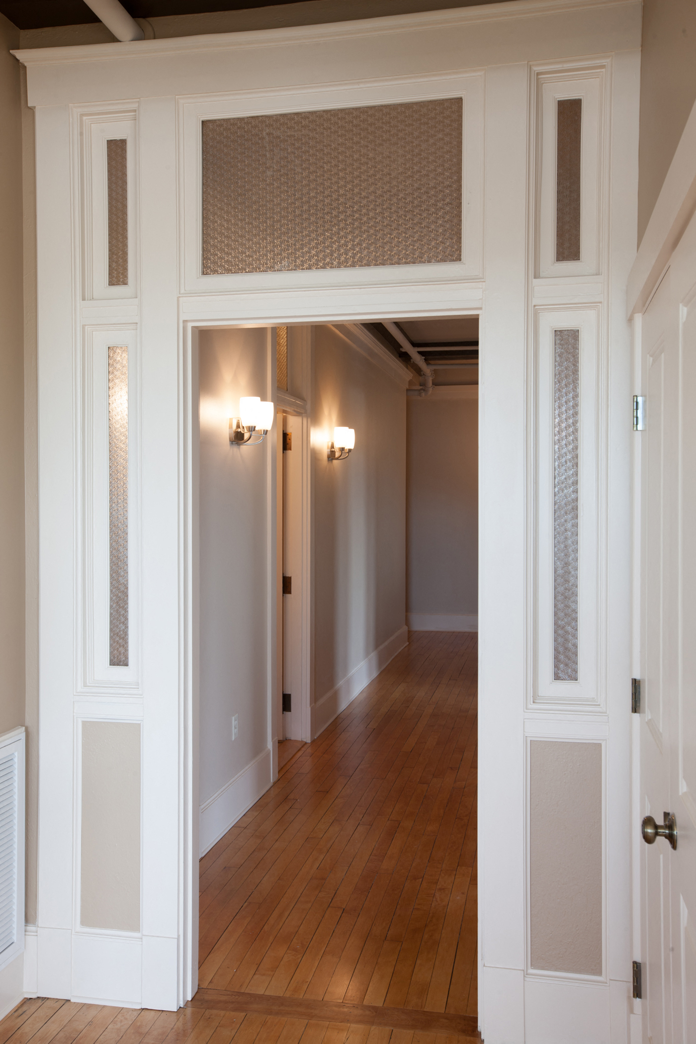 a hallway with white doors and a wood floor