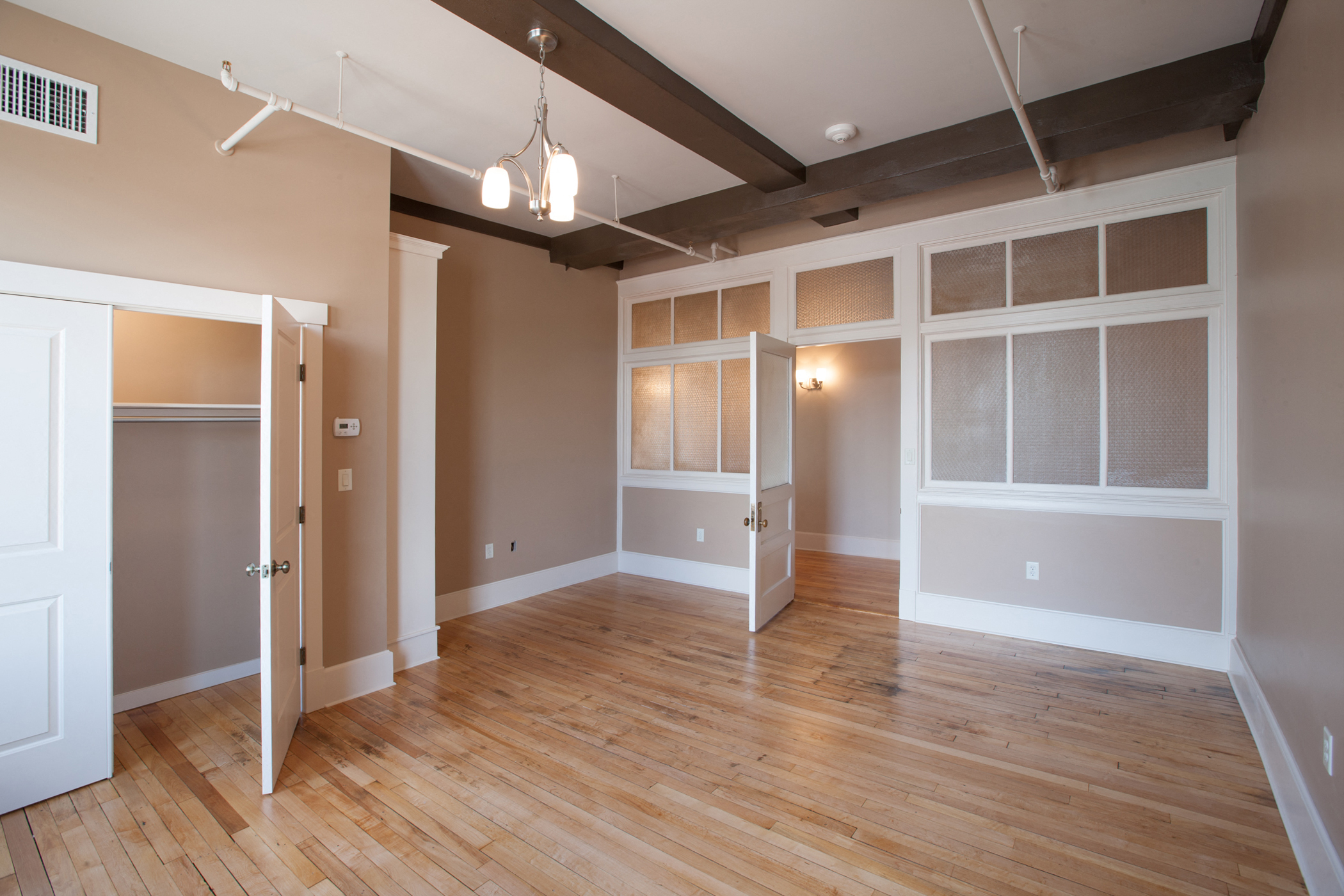 an empty living room with a wood floor and a closet