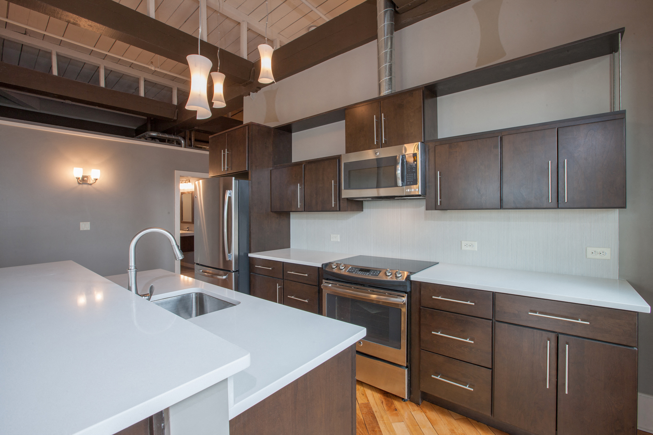 a kitchen with white counter tops and wooden cabinets