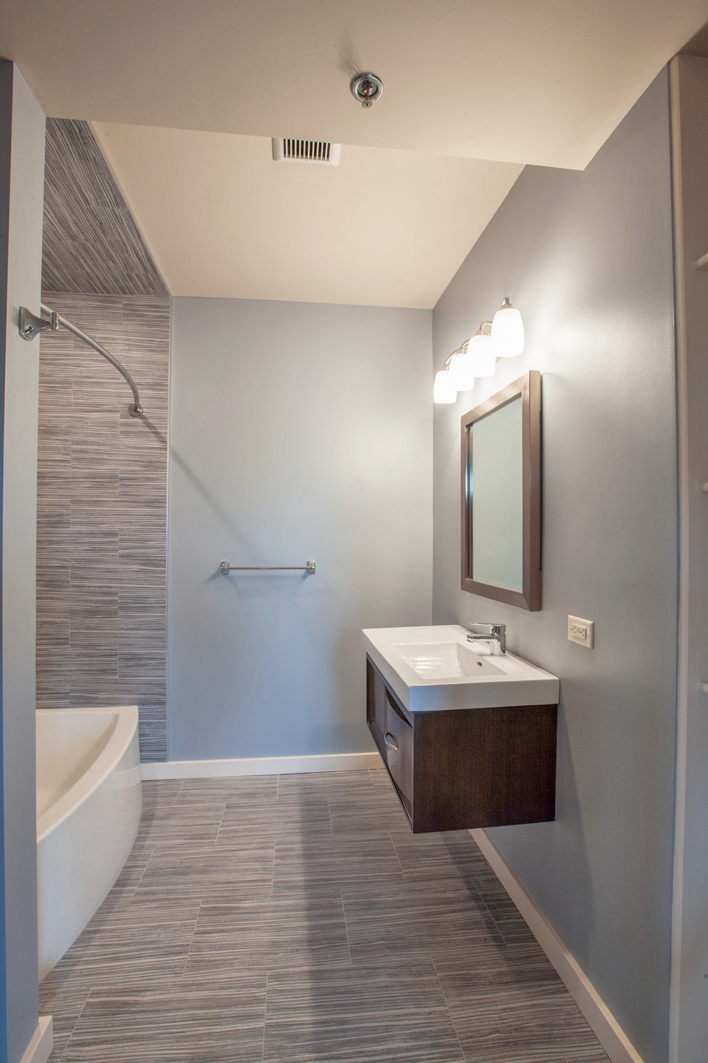 a bathroom with a sink and a shower and a mirror