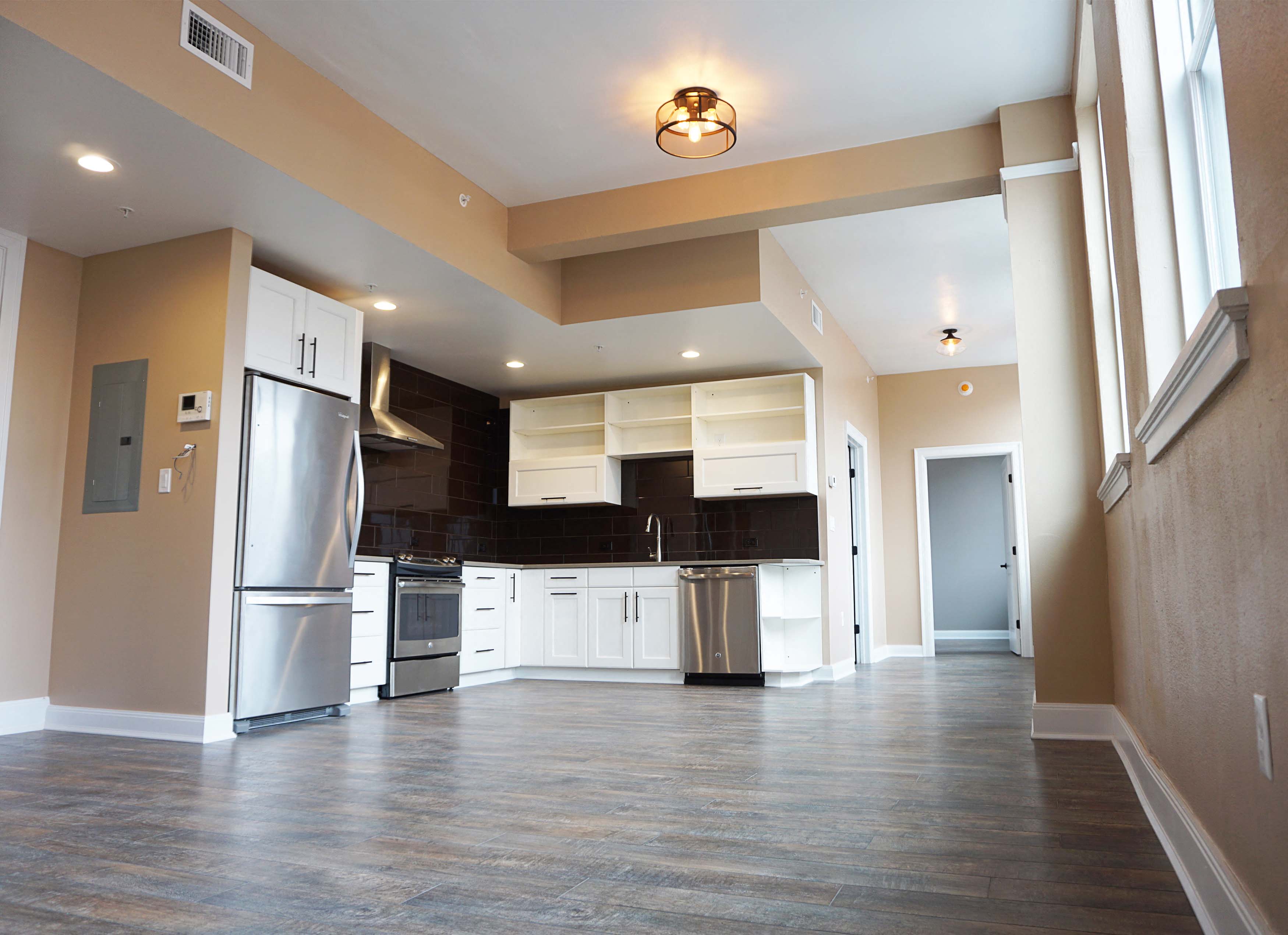 a kitchen with white cabinets and a stainless steel refrigerator