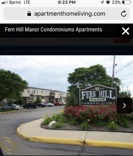 A sign for Fern Hill Manor Condominiums is displayed in front of a building.