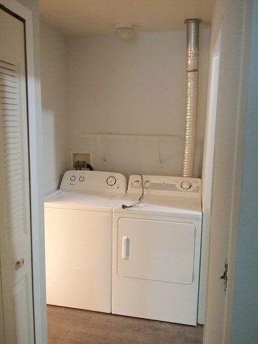 A small laundry room with a washer and dryer.
