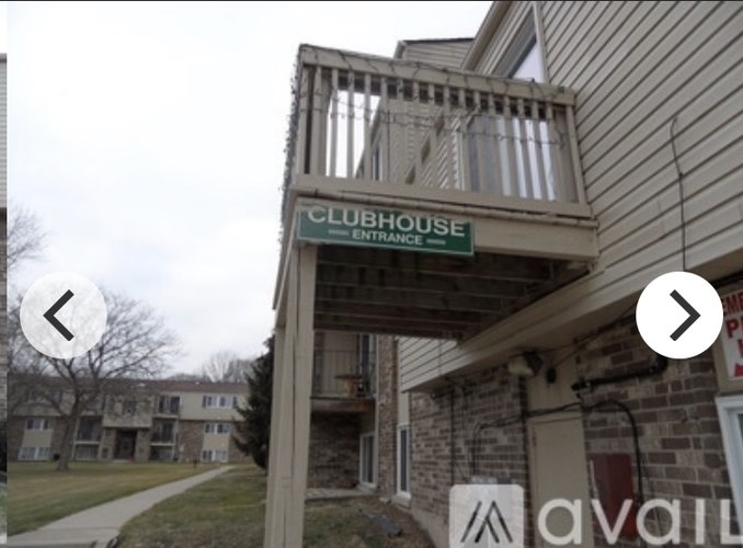 A clubhouse entrance sign is on a building.