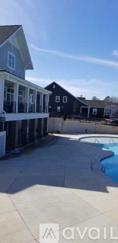 A pool area with a house in the background.