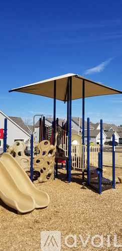 A playground with a slide and a shaded area.