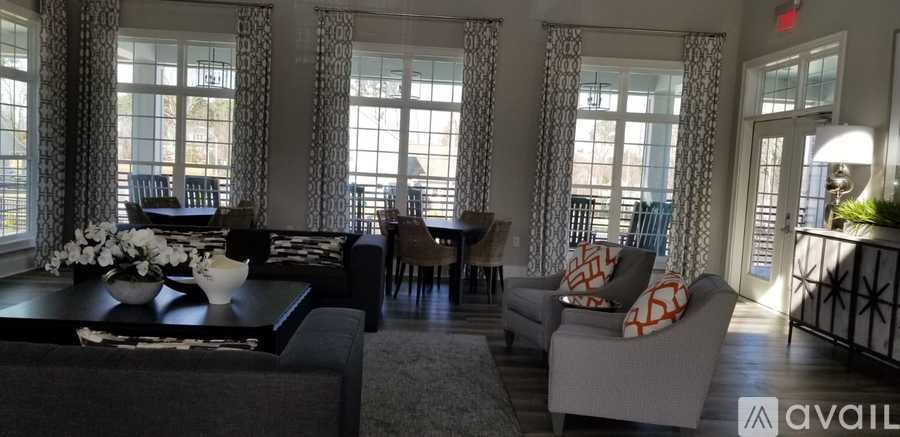A living room with a black couch and a coffee table with flowers on it.