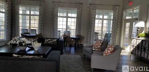 A living room with a black couch and a coffee table with flowers on it.