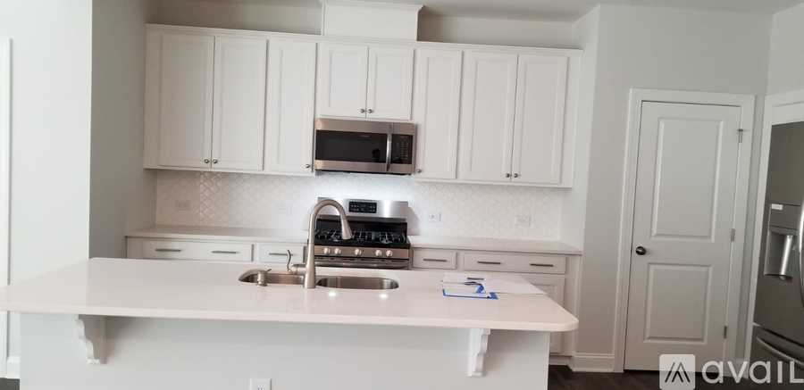 A kitchen with white cabinets and a white countertop.