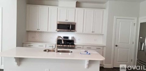 A kitchen with white cabinets and a white countertop.