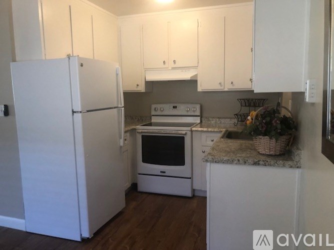 A kitchen with white appliances and cabinets.