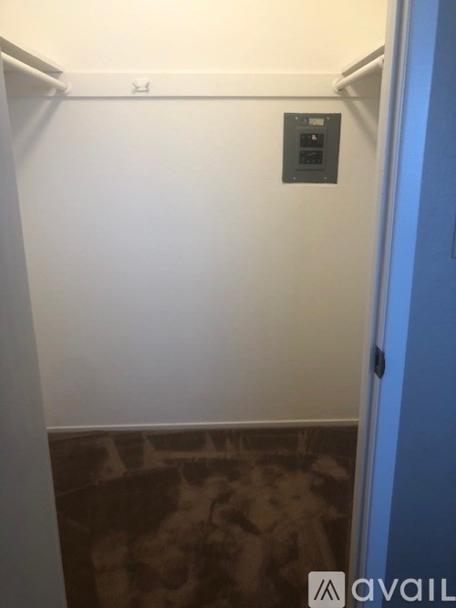 A wall-mounted thermostat is on a white wall.