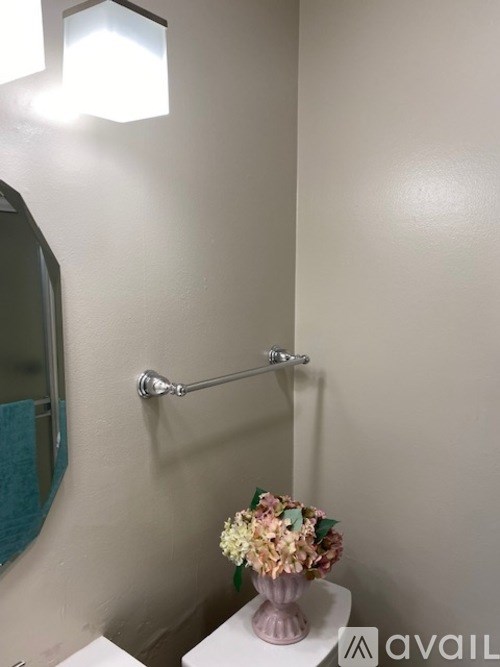 A white toilet with a flower vase on top of it.