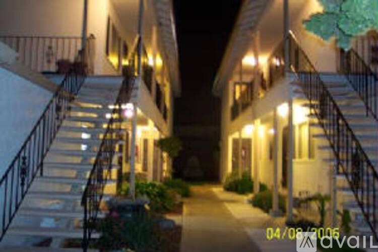 A nighttime view of a staircase leading to a building with lights on.