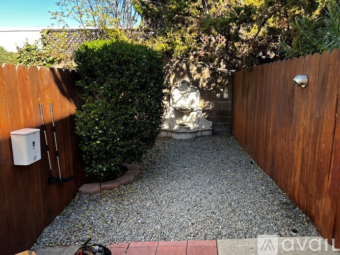 A small garden with a gravel path and a wooden fence.