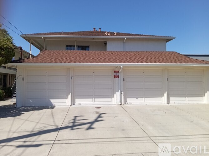 A two-car garage with a red roof and a white door.