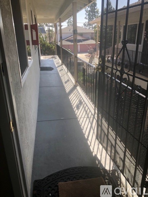 A black metal fence with a gate is in front of a house.