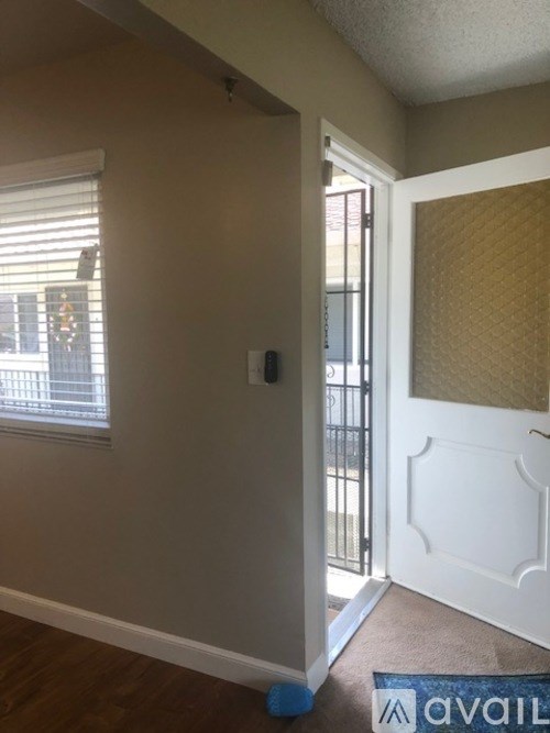 A hallway with a white door and a blue mat on the floor.