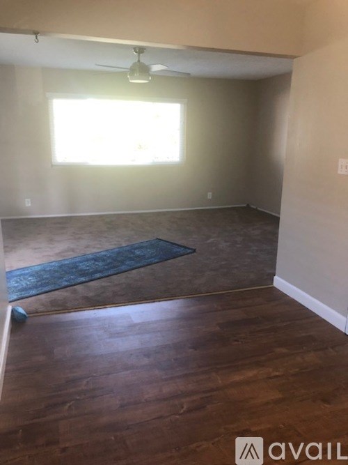 A room with a ceiling fan and a window.
