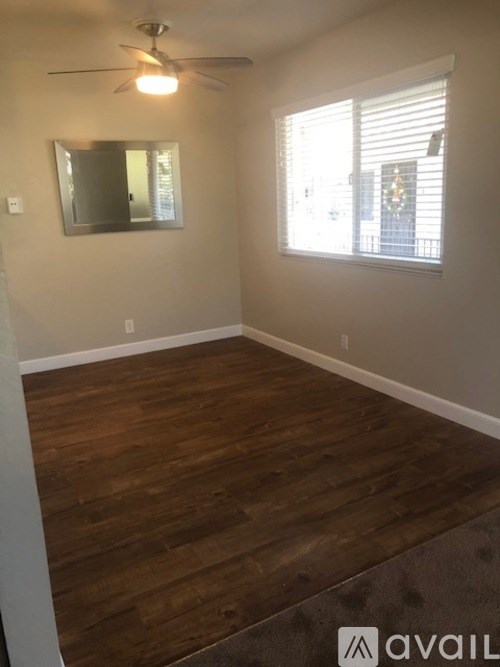 A room with wooden flooring and a ceiling fan.