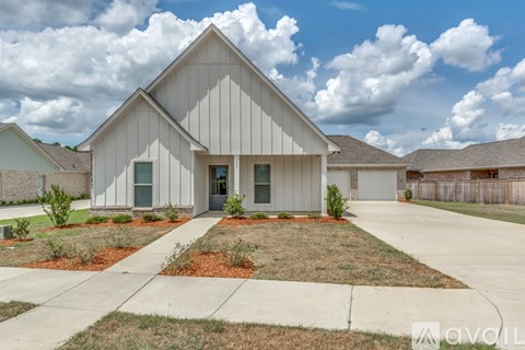 A modern house with a grey exterior and a large front yard.