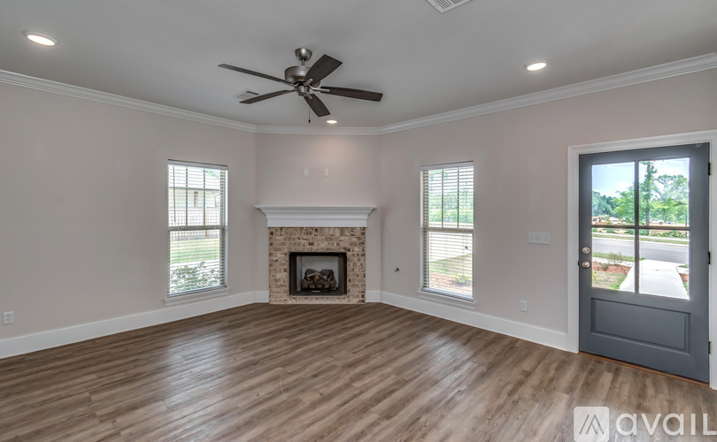 A spacious room with a fireplace and a ceiling fan.