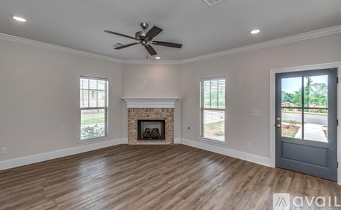 A spacious room with a fireplace and a ceiling fan.