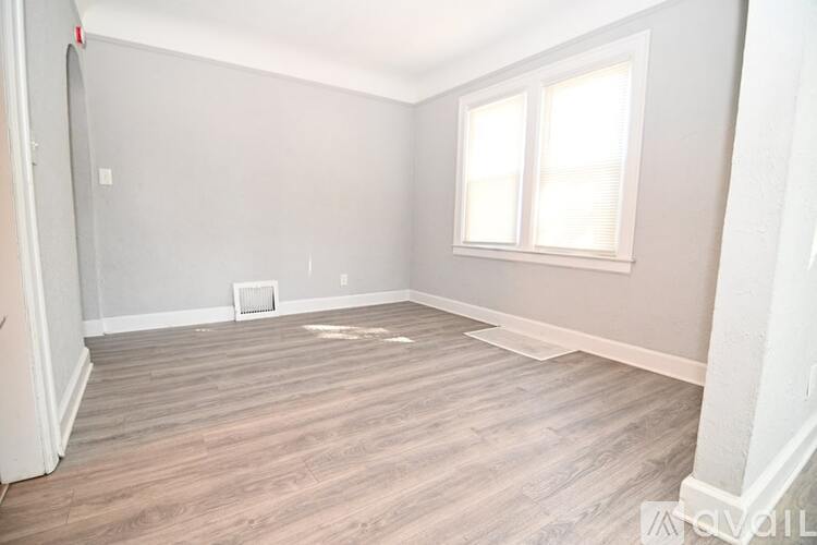 A bathroom with a white toilet, a white sink, and a shower with a grey shower curtain.