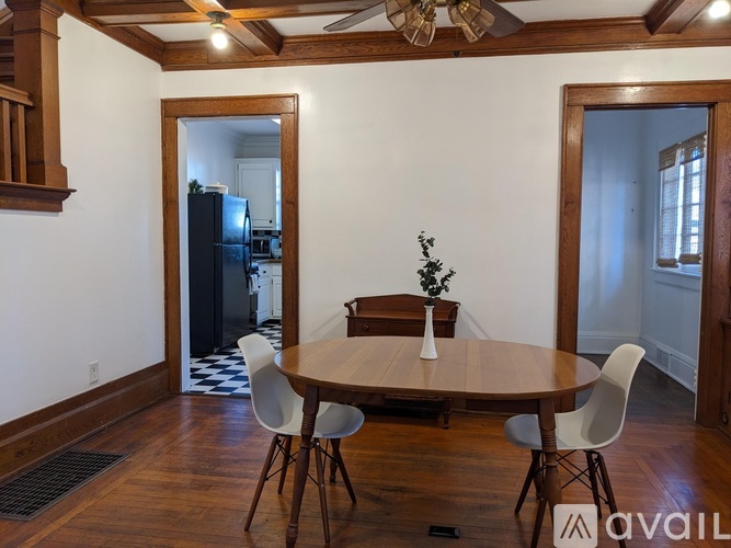 A dining room with a round table and chairs.