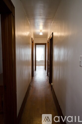 A long hallway with doors on both sides and a light at the end.