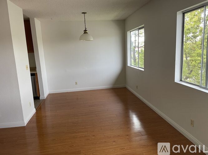 A room with wooden floors and a window on the right side.