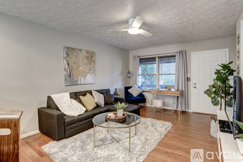 A living room with a grey couch, a coffee table, and a painting on the wall.