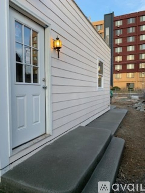 A white door with a window and a light on the wall.