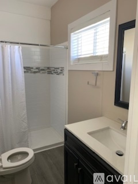 A bathroom with a toilet, sink and shower.