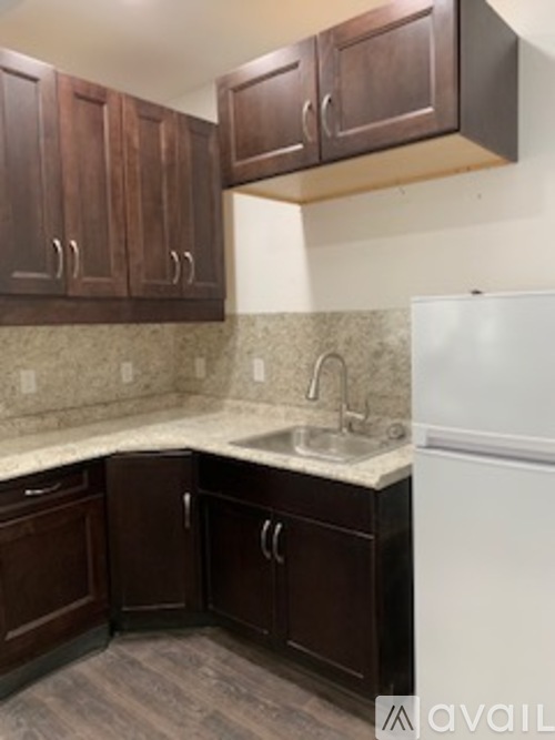 A kitchen with brown cabinets and a white refrigerator.
