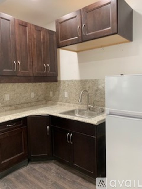A kitchen with brown cabinets and a white refrigerator.