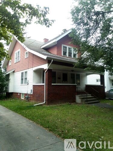 A red house with white trim and a porch.