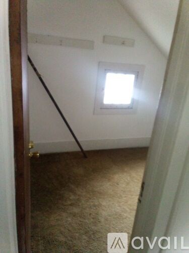 A room with a carpeted floor and a window.