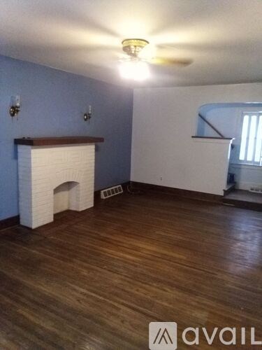 A room with a fireplace and wooden floors.